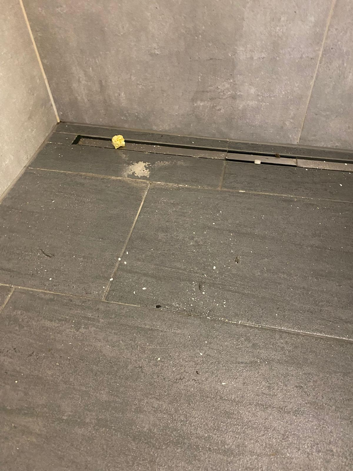 Vorher-Bild eines stark verkalkten Duschbodens